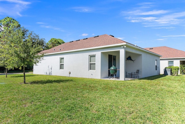 rear view of house featuring a patio area and a yard