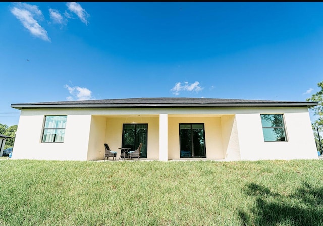 back of house with a patio and a yard