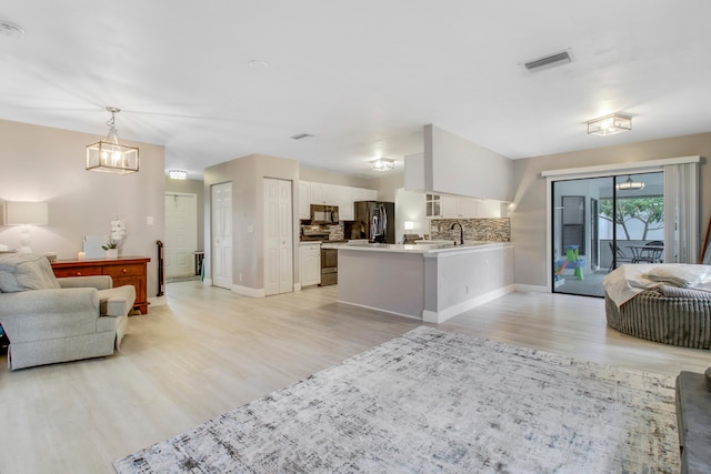 living room with sink, lofted ceiling, and light wood-type flooring