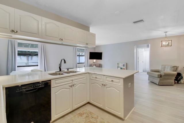 kitchen with white cabinets, sink, dishwasher, light hardwood / wood-style floors, and hanging light fixtures