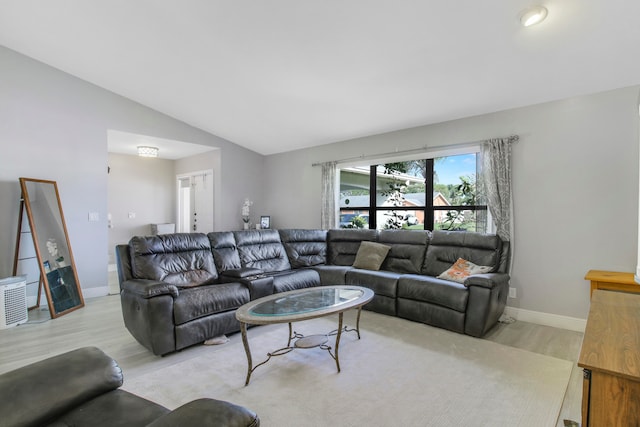 living room with light wood-type flooring and vaulted ceiling