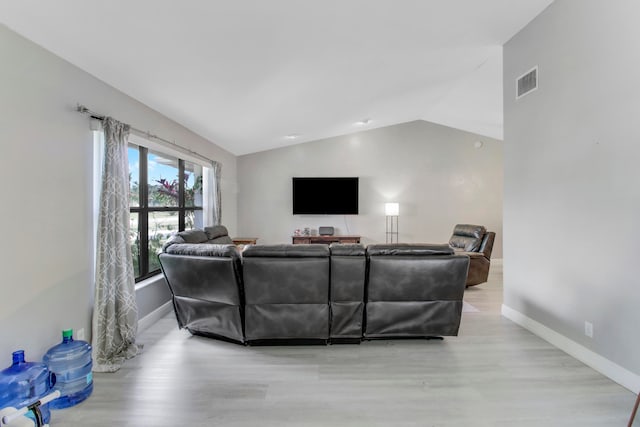 living room with light hardwood / wood-style floors and lofted ceiling