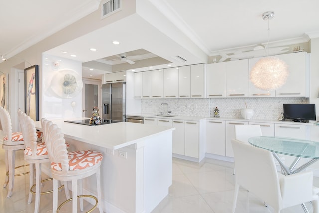 kitchen featuring sink, white cabinetry, stainless steel appliances, and hanging light fixtures