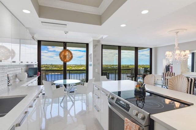 2003 N Ocean Blvd Unit 1203, Boca Raton, FL 33431 - kitchen with electric range, light tile patterned floors, a chandelier, white cabinets, and ornamental molding