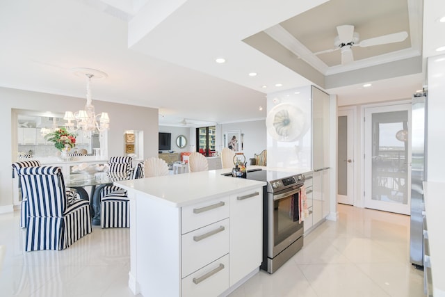 kitchen featuring ceiling fan with notable chandelier, white cabinets, hanging light fixtures, and stainless steel range with electric stovetop