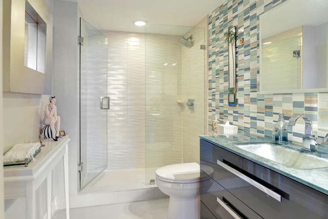 bathroom with walk in shower, backsplash, toilet, vanity, and tile walls