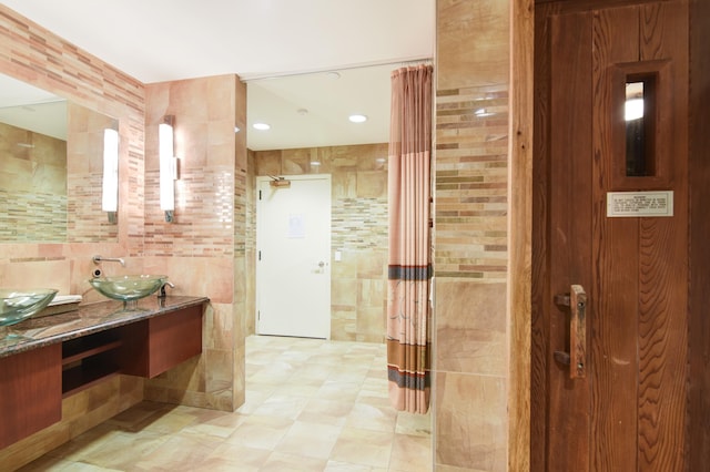 bathroom featuring vanity and tile walls