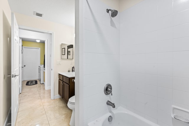 full bathroom with tiled shower / bath, a textured ceiling, vanity, tile patterned floors, and toilet