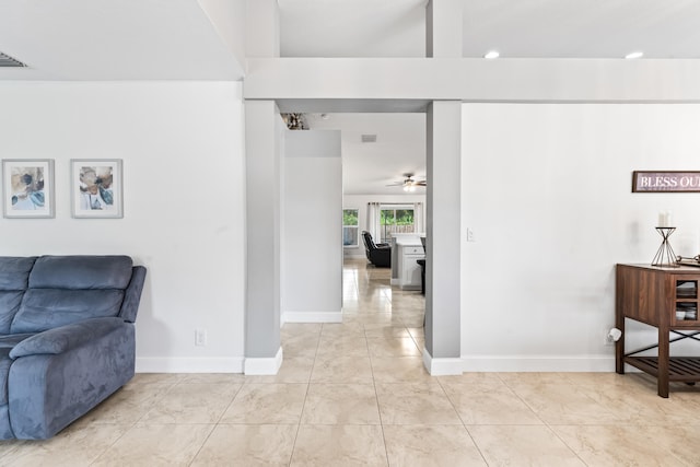 corridor with light tile patterned floors and beam ceiling