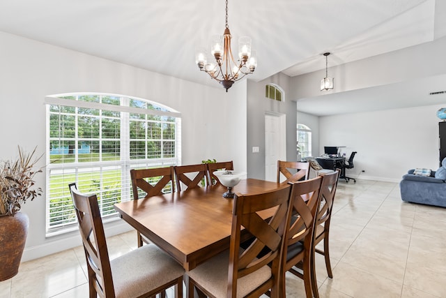 dining area with a wealth of natural light, light tile patterned flooring, and an inviting chandelier