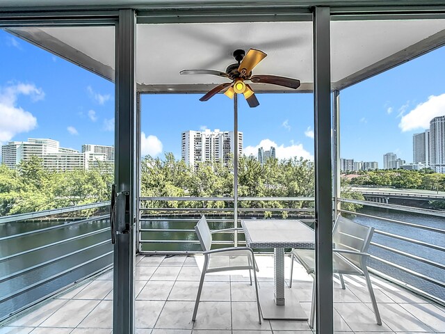 unfurnished sunroom with ceiling fan and a water view