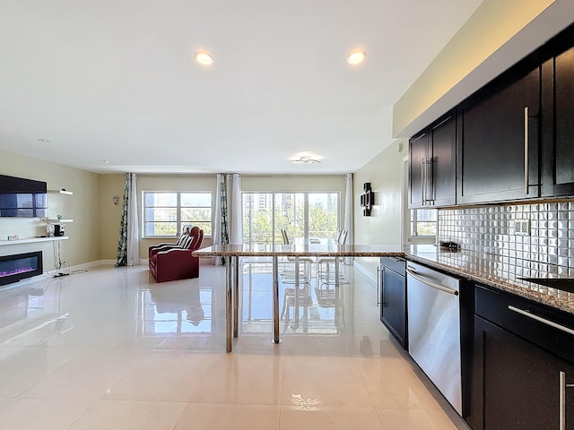 kitchen featuring stainless steel dishwasher, light tile patterned floors, backsplash, and stone counters