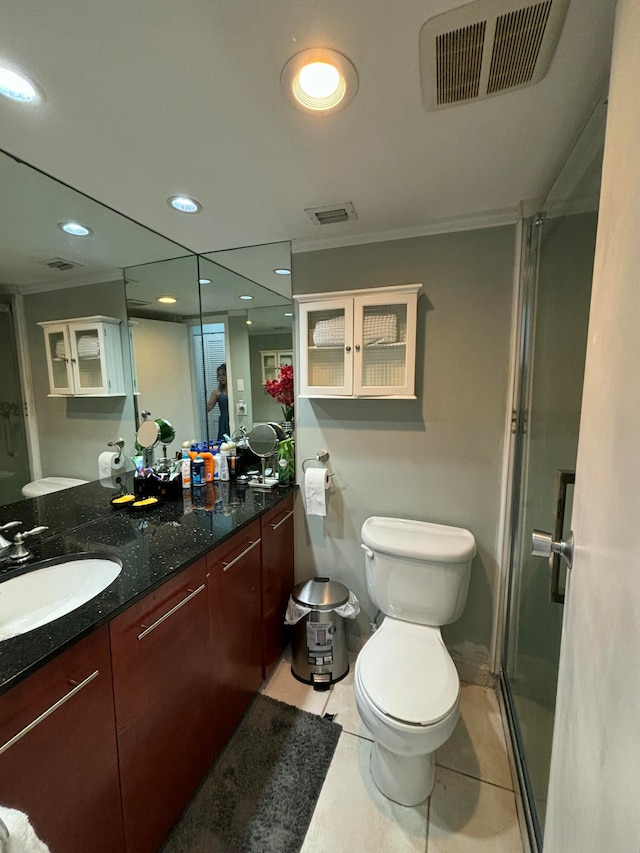 bathroom featuring toilet, a shower with door, vanity, and tile patterned flooring