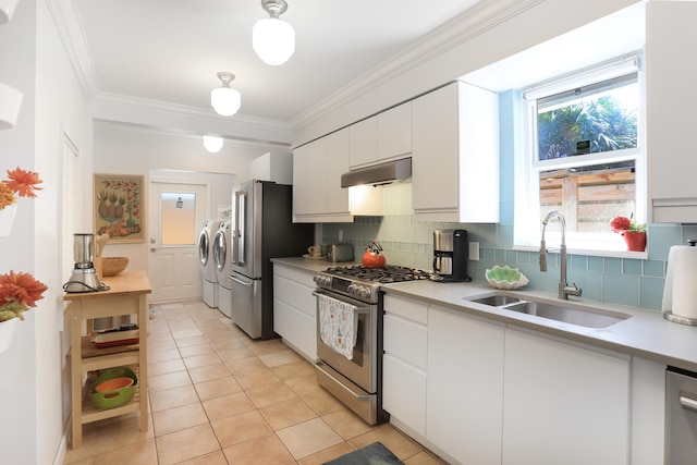 kitchen featuring stainless steel appliances, separate washer and dryer, plenty of natural light, and white cabinetry