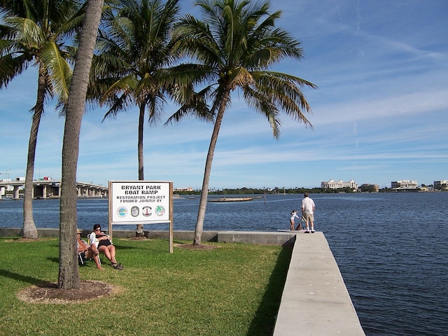 dock area with a lawn and a water view