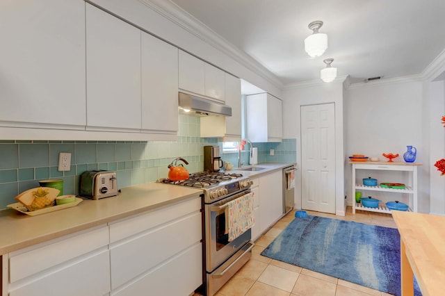 kitchen with stainless steel appliances, white cabinetry, sink, light tile patterned floors, and crown molding