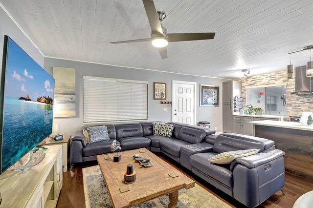 living room with dark hardwood / wood-style floors, ceiling fan, ornamental molding, and wood ceiling