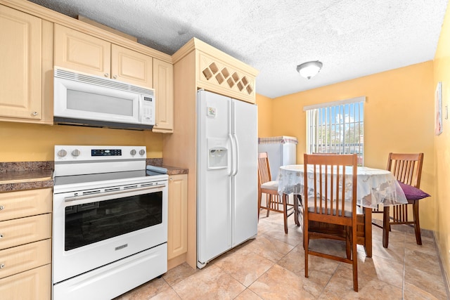 kitchen featuring white appliances, a textured ceiling, and light tile patterned flooring