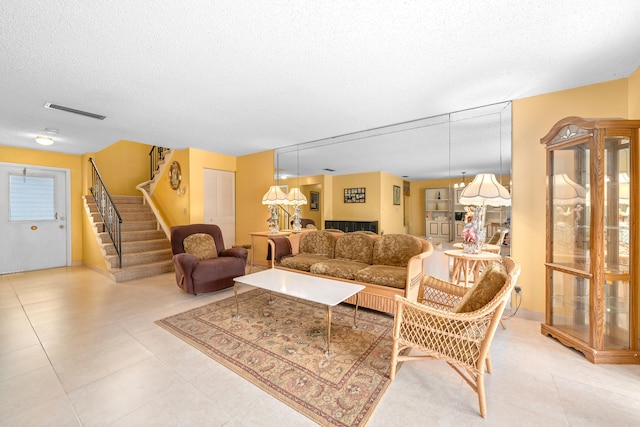 tiled living room featuring a textured ceiling