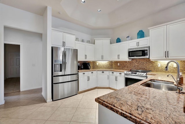 kitchen with white cabinets, decorative backsplash, stainless steel appliances, and sink