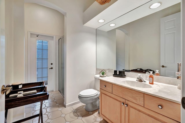 bathroom featuring toilet, an enclosed shower, vanity, and tile patterned floors