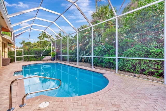 view of swimming pool with glass enclosure and a patio area