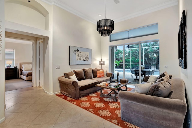 tiled living room with a high ceiling, an inviting chandelier, and ornamental molding