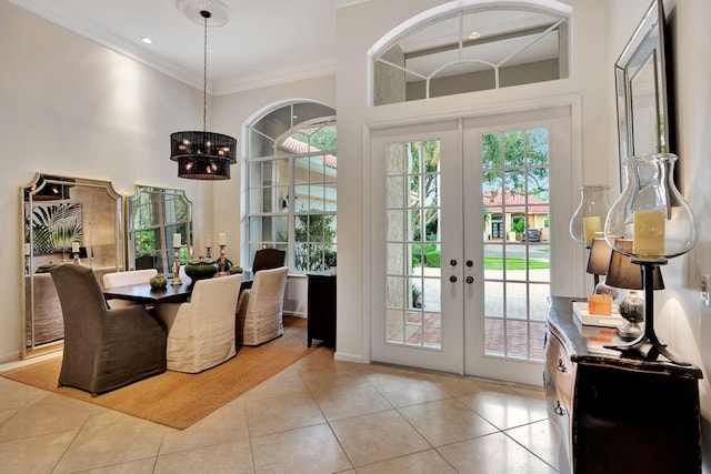 entryway with french doors, light tile patterned floors, a healthy amount of sunlight, and crown molding