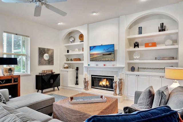 living room with built in features and ceiling fan