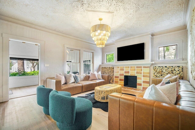 living room featuring a textured ceiling, wood-type flooring, a chandelier, and crown molding