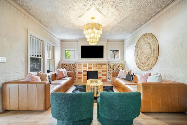 living room featuring ornamental molding, light hardwood / wood-style floors, a textured ceiling, and a chandelier