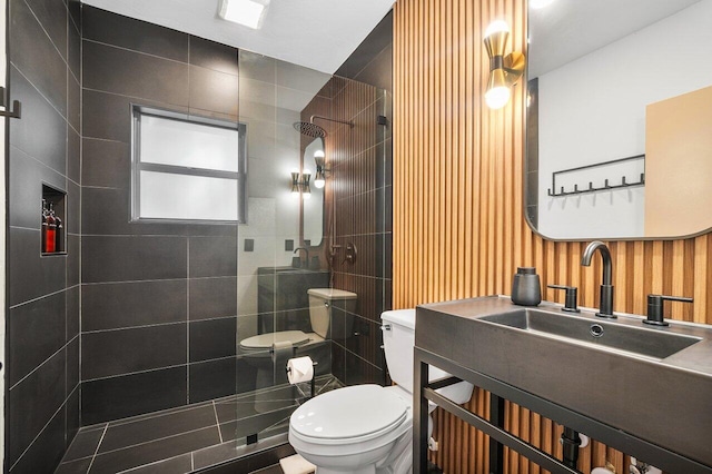 bathroom with tiled shower, toilet, and vanity