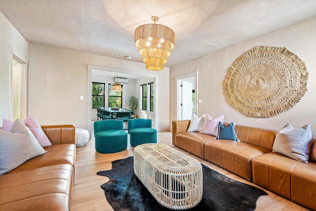 living room with an inviting chandelier, hardwood / wood-style flooring, and a textured ceiling