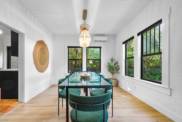 dining room featuring hardwood / wood-style flooring, a textured ceiling, a healthy amount of sunlight, and a wall mounted air conditioner