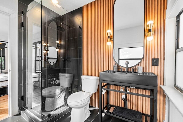 bathroom with tile patterned floors, toilet, and an enclosed shower