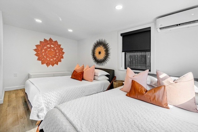 bedroom featuring hardwood / wood-style floors and a wall unit AC