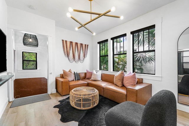 living room with a chandelier, light hardwood / wood-style floors, and a healthy amount of sunlight