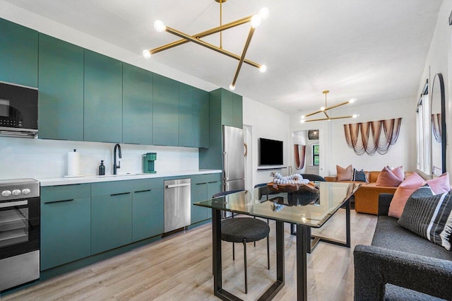 kitchen with stainless steel appliances, sink, tasteful backsplash, light wood-type flooring, and decorative light fixtures