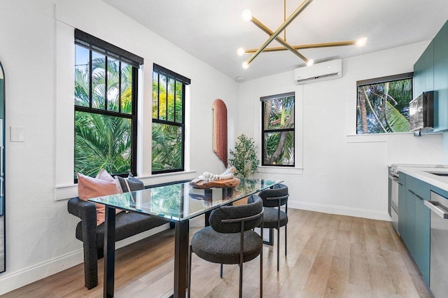 dining room with a wall unit AC, an inviting chandelier, and light hardwood / wood-style floors