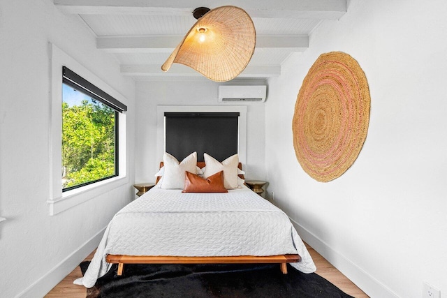 bedroom featuring hardwood / wood-style floors, beam ceiling, and a wall mounted air conditioner