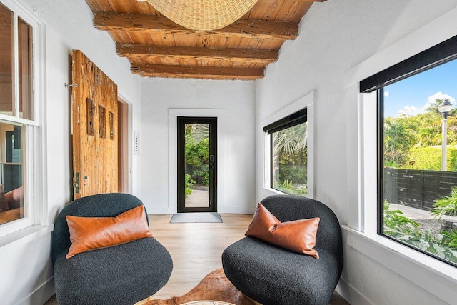 sitting room featuring light wood-type flooring, plenty of natural light, and wooden ceiling