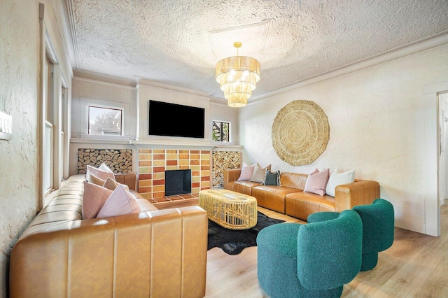 living room with a textured ceiling, light wood-type flooring, and ornamental molding