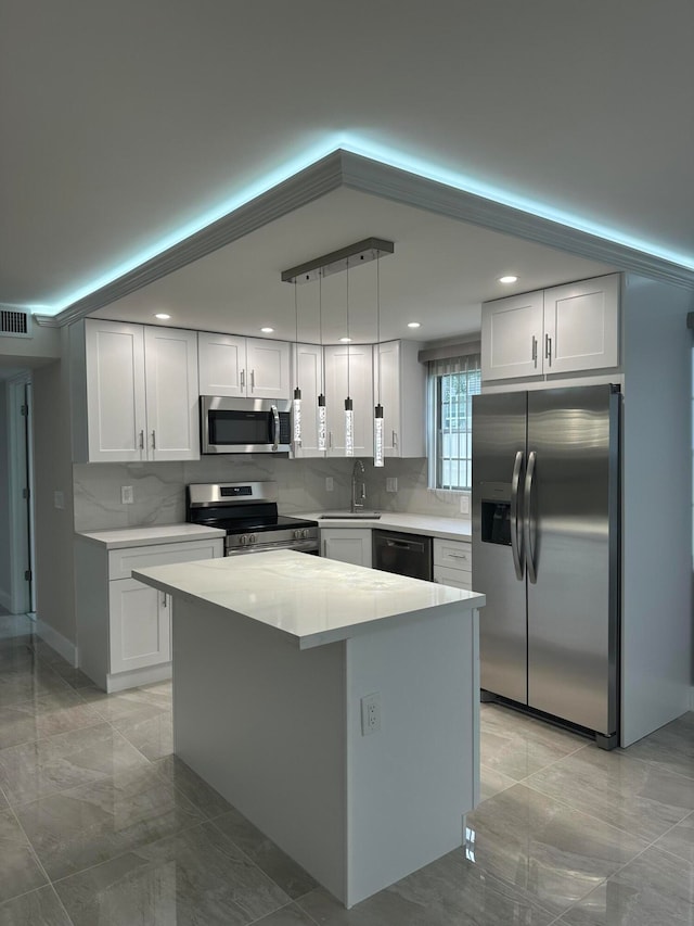 kitchen with white cabinets, a center island, hanging light fixtures, and stainless steel appliances