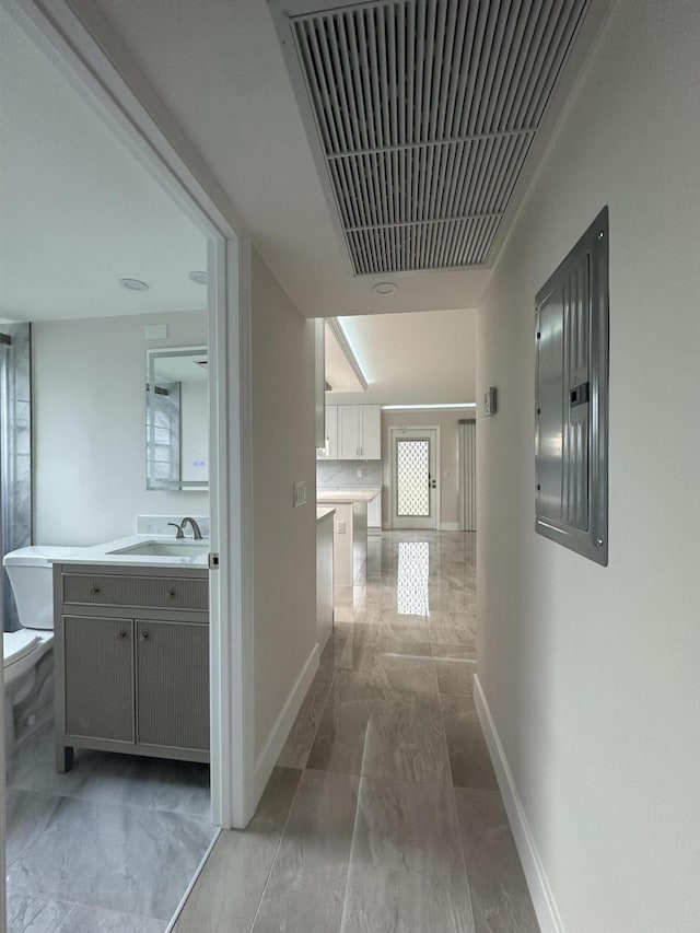 256 Suffolk Unit G, Boca Raton, FL 33434 - hallway with a sink, electric panel, light marble finish floors, and baseboards