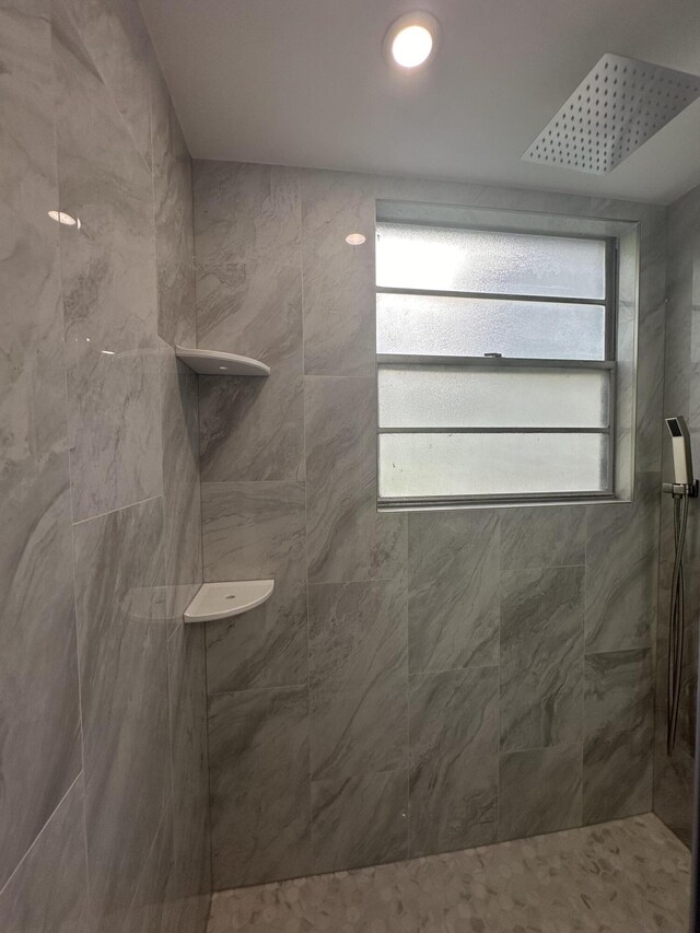 256 Suffolk Unit G, Boca Raton, FL 33434 - bathroom featuring a tile shower and healthy amount of natural light
