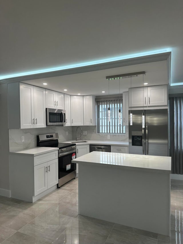 kitchen with white cabinets, hanging light fixtures, sink, and appliances with stainless steel finishes