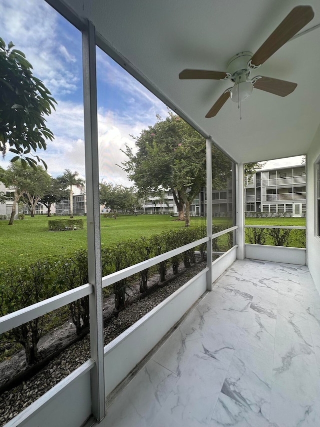 unfurnished sunroom featuring ceiling fan