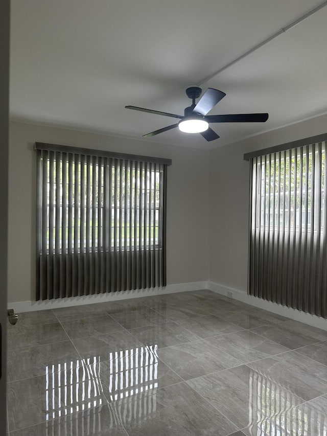 256 Suffolk Unit G, Boca Raton, FL 33434 - empty room featuring plenty of natural light, a ceiling fan, and baseboards