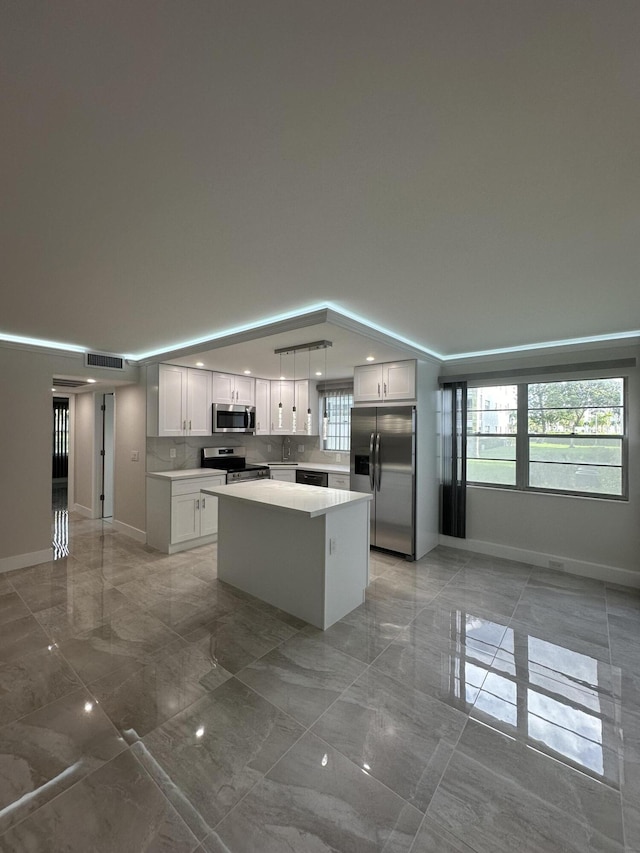256 Suffolk Unit G, Boca Raton, FL 33434 - kitchen featuring appliances with stainless steel finishes, light marble finish flooring, a center island, and light countertops