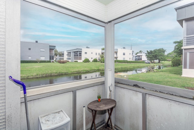 sunroom / solarium featuring a water view